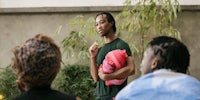 a man holding a baby in front of a group of people